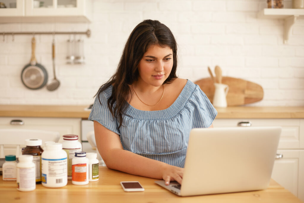 Weight gainer supplement powder with a measuring scoop beside a glass of prepared shake, illustrating high-calorie nutritional supplement for muscle gain and healthy weight increase.